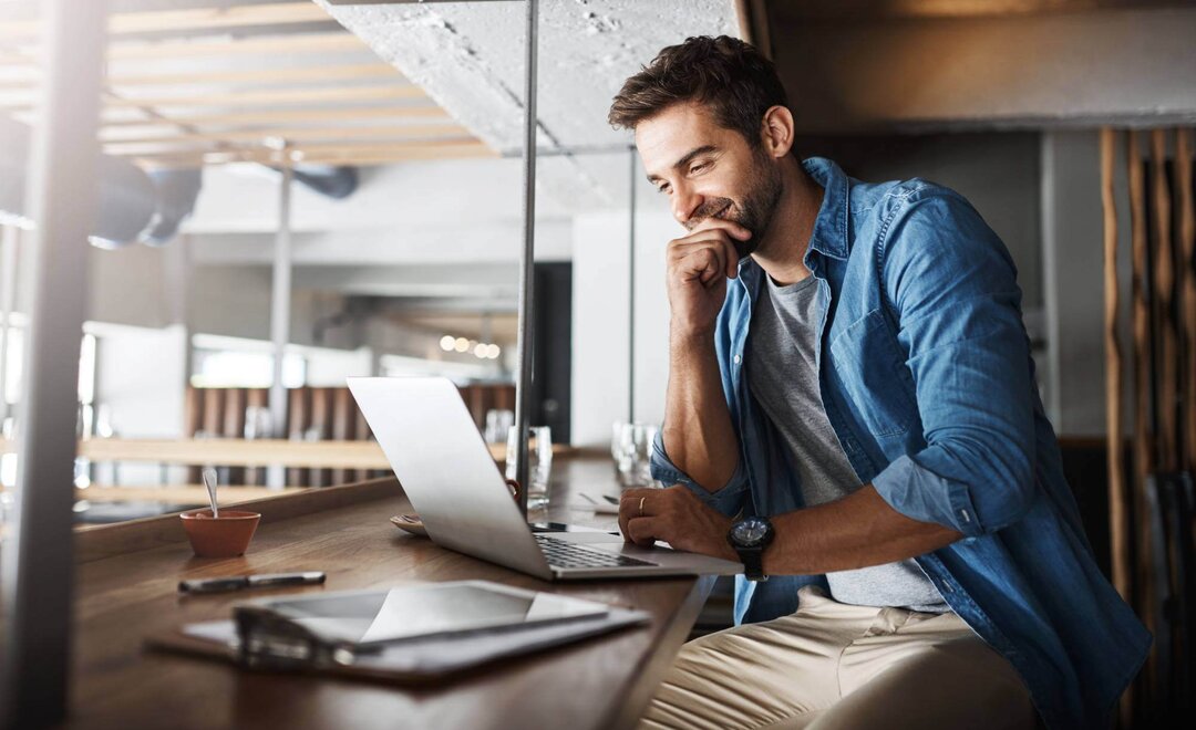 Mann in einem Café mit Laptop
